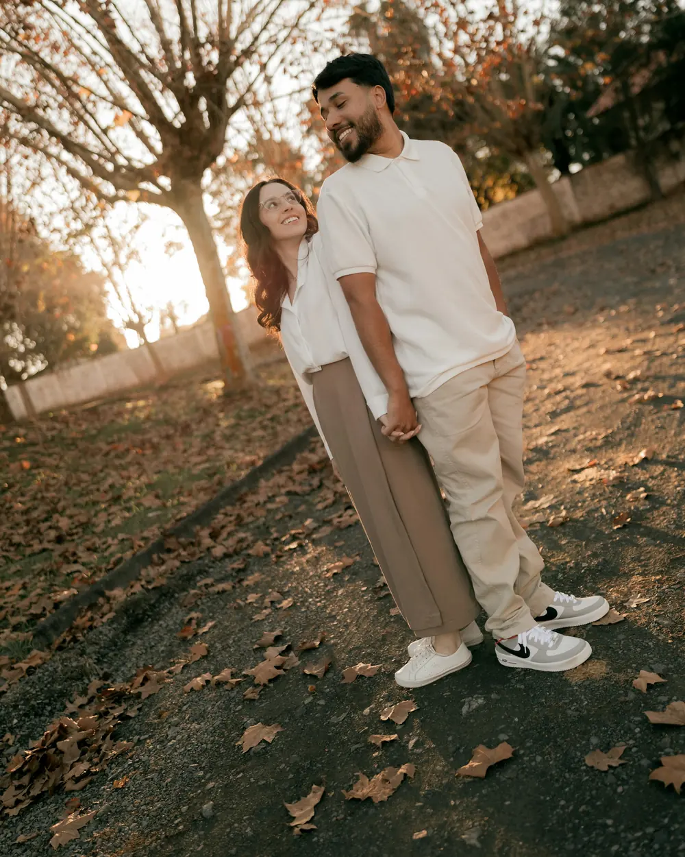 A couple laughing together beneath autumn trees